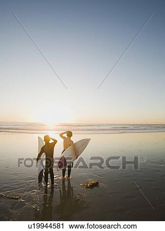 Stock Image - Kids on beach with surfboards. Fotosearch