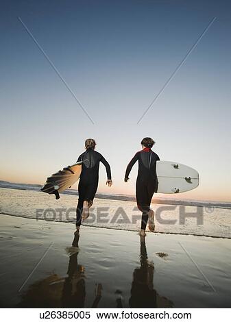 Stock Photography - Kids on beach with surfboards. Fotosearch