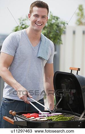 Stock Image - Man barbequing. Fotosearch