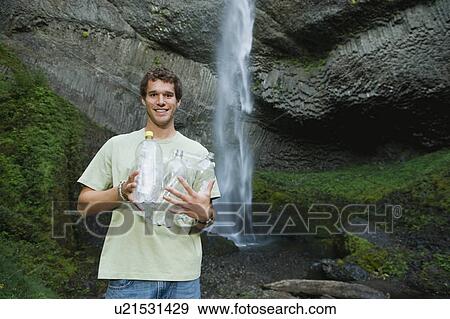 Man holding empty water bottles View Large Photo Image Stock Photo - Man holding empty water bottles. Fotosearch