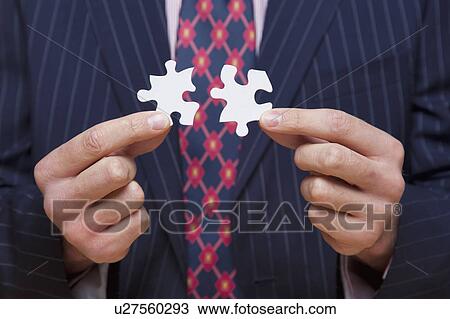 Man holding jigsaw puzzle pieces View Large Photo Image Stock Image - Man holding jigsaw puzzle pieces. Fotosearch