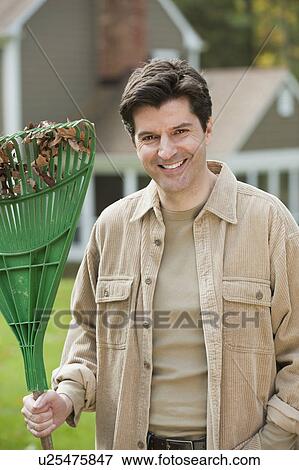 Man holding rake View Large Photo Image Stock Photo - Man holding rake. Fotosearch