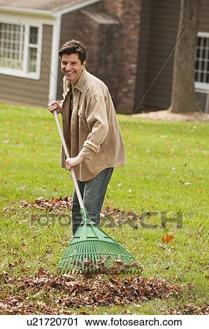 Stock Image - Man raking leaves. Fotosearch