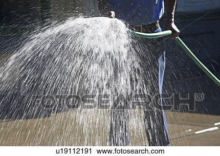 Man spraying hose View Large Photo Image Stock Image - Man spraying hose. Fotosearch