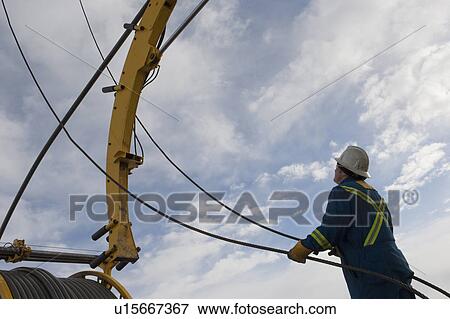 Stock Photo - Man working with drilling equipment. Fotosearch