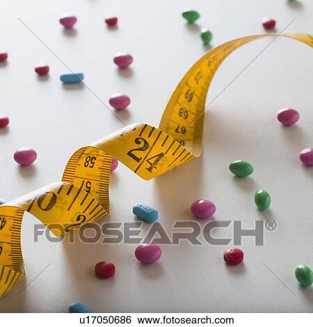 Stock Photograph - Measuring tape and diet pills. Fotosearch