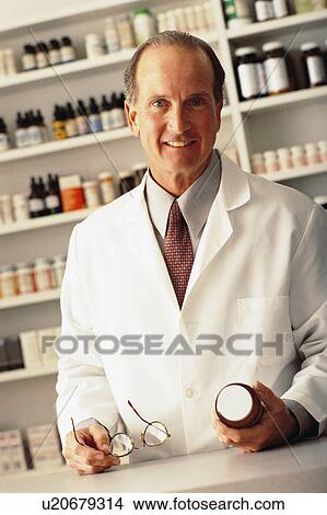 Pharmacist holding bottle of pills View Large Photo Image Picture - Pharmacist holding bottle of pills. Fotosearch