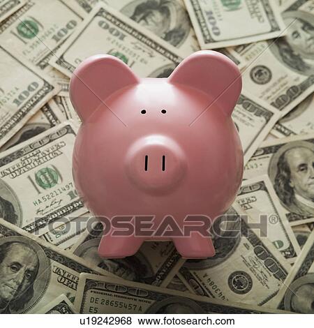 Stock Photo - Piggy Bank on top of American currency. Fotosearch