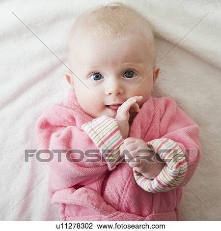 Stock Image - Portrait of baby girl in pink robe. Fotosearch