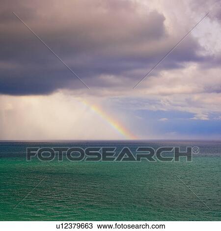 Stock Image - Rainbow over ocean. Fotosearch