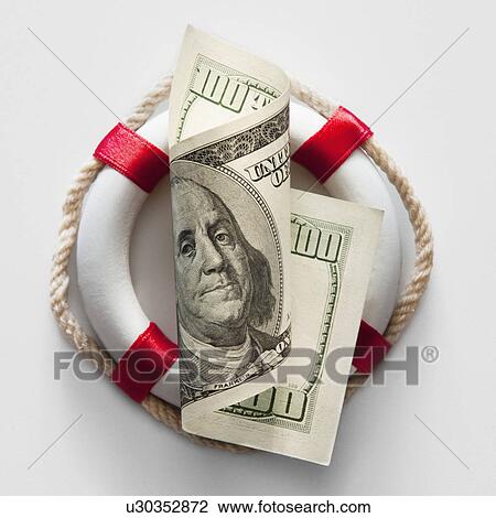 Stock Image - Ring buoy behind American currency. Fotosearch