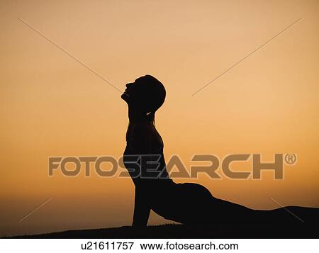 Stock Photo - Silhouette of woman doing yoga. Fotosearch