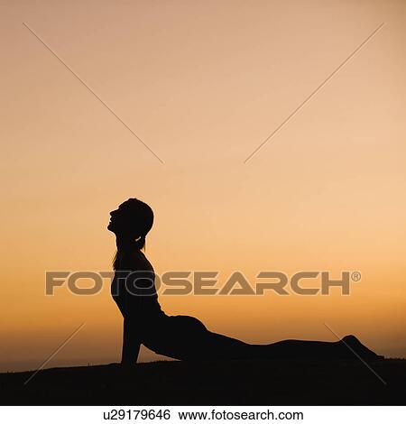 Stock Photograph - Silhouette of woman doing yoga. Fotosearch