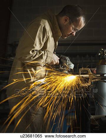 Stock Photography - Steel grinder working in metal shop. Fotosearch