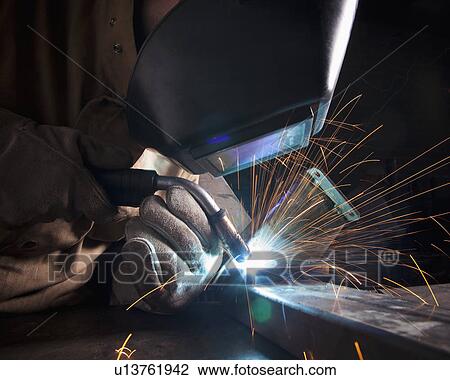 Stock Image - Steel worker in metal shop. Fotosearch