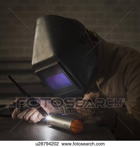Stock Image - Steel worker in metal shop. Fotosearch