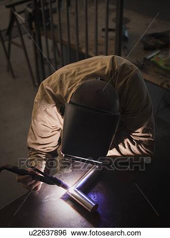 Stock Photograph - Steel worker in metal shop. Fotosearch