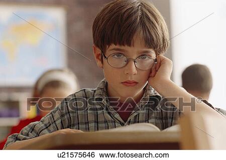 Stock Photograph - Student sitting at desk in classroom. Fotosearch