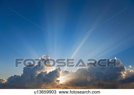 Stock Image - Sunset behind clouds. Fotosearch