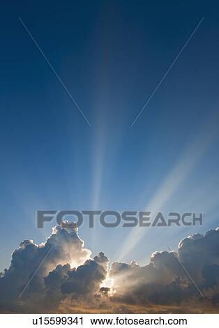 Stock Image - Sunset behind clouds. Fotosearch