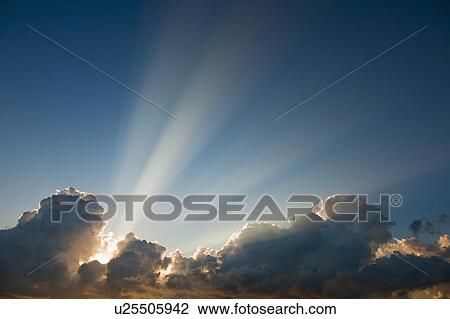 Stock Image - Sunset behind clouds. Fotosearch