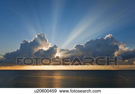 Stock Photo - Sunset behind clouds. Fotosearch