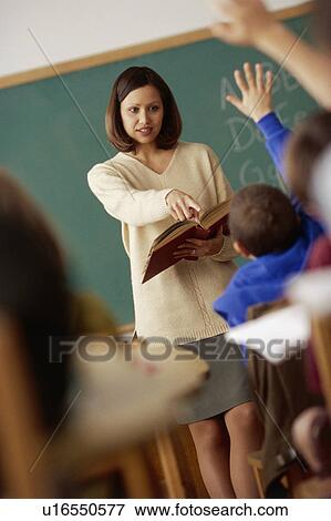 Teacher calling on student in classroom View Large Photo Image Stock Photo - Teacher calling on student in classroom. Fotosearch