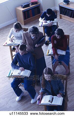 Teacher helping students in classroom View Large Photo Image Stock Image - Teacher helping students in classroom. Fotosearch