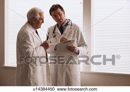 Stock Image - Two doctors looking at chart. Fotosearch