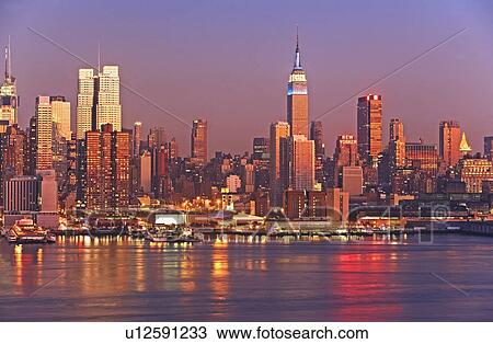 Stock Image - Waterfront buildings at sunset. Fotosearch