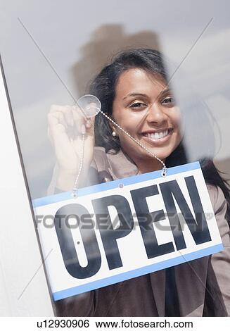Stock Photograph - Woman behind open sign. Fotosearch