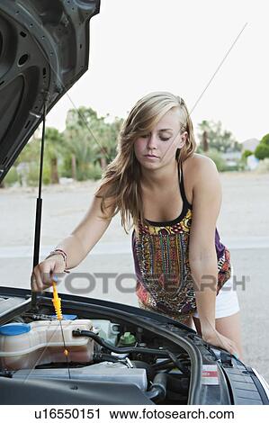 Stock Image - Woman checking car's oil. Fotosearch