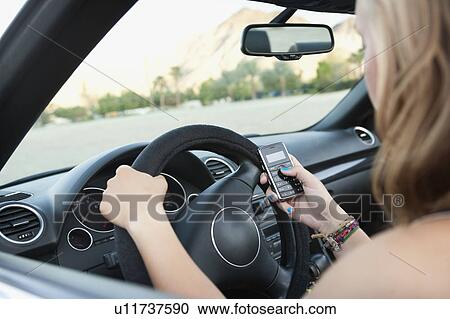 Stock Image - Woman driving convertible. Fotosearch