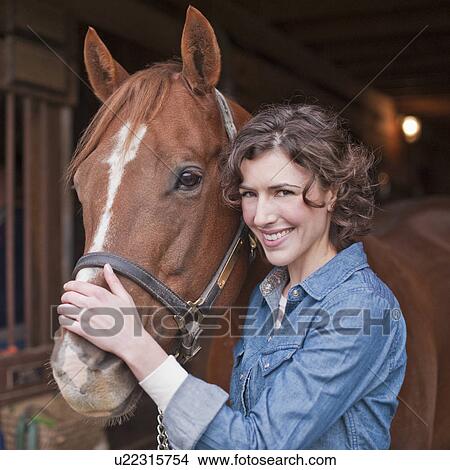 Picture - Woman holding horse. Fotosearch