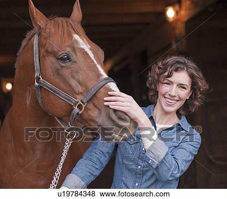 Stock Photo - Woman holding horse. Fotosearch
