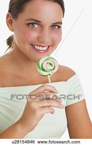 Stock Photograph - Woman holding lollipop. Fotosearch