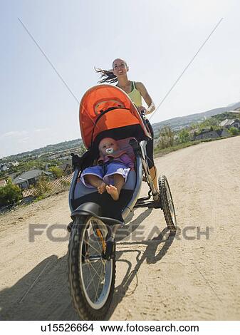 Picture - Woman jogging with stroller. Fotosearch
