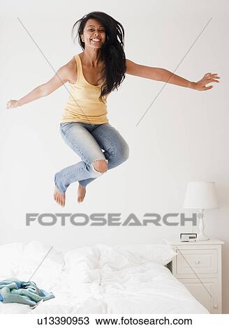 Woman jumping on bed View Large Photo Image Stock Image - Woman jumping on bed. Fotosearch