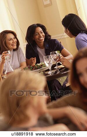 Stock Photo - Woman laughing over dinner. Fotosearch