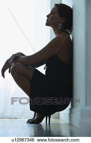 Stock Photograph - Woman leaning against wall. Fotosearch