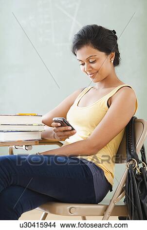 Picture - Woman looking at cellular phone. Fotosearch