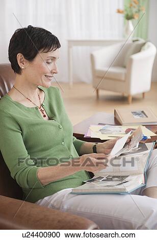 Stock Image - Woman looking at photographs. Fotosearch