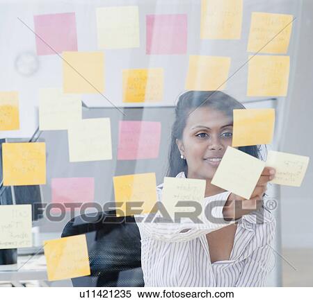 Woman looking at post-it notes View Large Photo Image Stock Photography - Woman looking at post-it notes. Fotosearch