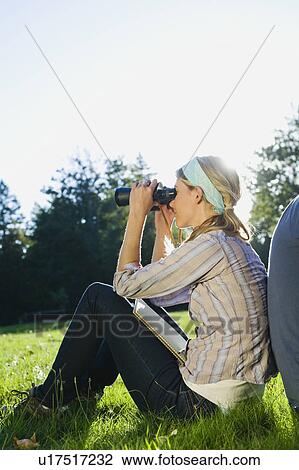 Woman looking through binoculars View Large Photo Image Stock Image - Woman looking through binoculars. Fotosearch