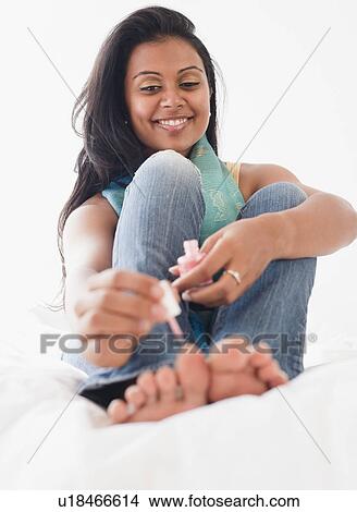 Picture - Woman painting toe nails. Fotosearch