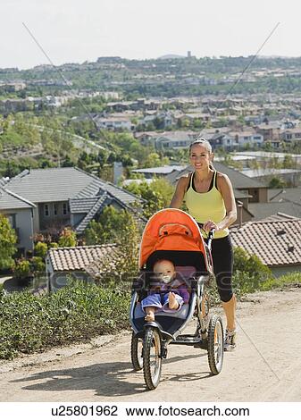 Stock Image - Woman pushing stroller. Fotosearch