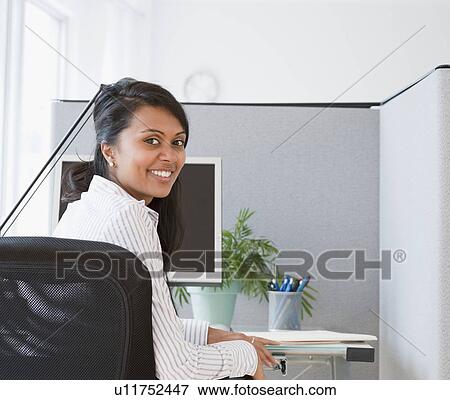 Stock Photo - Woman sitting at desk. Fotosearch