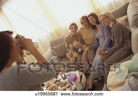 Stock Photo - Woman taking picture at baby shower. Fotosearch