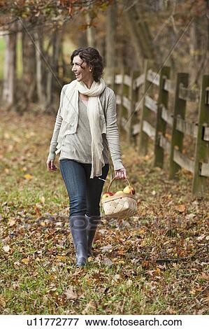 Woman walking with basket of apples View Large Photo Image Stock Photo - Woman walking with basket of apples. Fotosearch