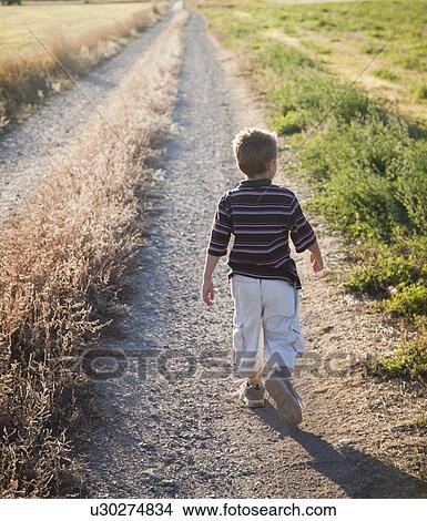 Young boy walking on rural path View Large Photo Image Picture - Young boy walking on rural path. Fotosearch